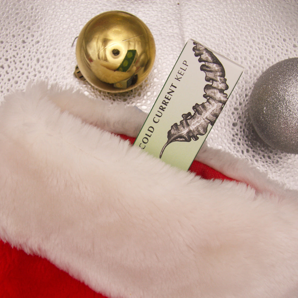 Red and white Christmas stocking with gold and silver ornaments on a textured surface